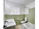 Bathroom featuring a toilet, bathtub, window and light green tile at 1083 Amelia Sw Dr, Marietta, GA 30060