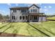 Exterior showcasing a gray two-story home with a well-maintained lawn and covered patio at 1975 Sage Lake Bend Sw, Marietta, GA 30064