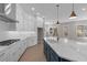Bright kitchen featuring stainless steel appliances, an island with quartz countertops and modern pendant lights at 1975 Sage Lake Bend Sw, Marietta, GA 30064