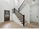 Inviting entryway with staircase, modern wood door with decorative glass, and wood flooring at 7180 Whitfield Dr, Riverdale, GA 30296