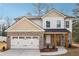 Beautiful two-story home with brick and white siding, a covered porch, and attached two-car garage at 7180 Whitfield Dr, Riverdale, GA 30296