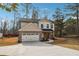 Charming two-story house featuring a brick and siding exterior, two-car garage, and a long driveway at 7180 Whitfield Dr, Riverdale, GA 30296