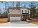 Inviting two-story residence with a brick facade, white siding, and an attached two-car garage at 7180 Whitfield Dr, Riverdale, GA 30296