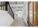 Bright foyer with light wood floors, black staircase, and open sightlines to the living spaces at 7180 Whitfield Dr, Riverdale, GA 30296