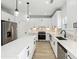 Modern kitchen featuring stainless steel appliances, white cabinets, quartz counters, and pendant lighting at 7180 Whitfield Dr, Riverdale, GA 30296
