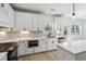 Bright kitchen with stainless steel appliances, white cabinets, quartz countertops, and breakfast bar at 7180 Whitfield Dr, Riverdale, GA 30296