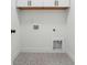 This laundry room has stylish gray and white patterned tile flooring and white cabinetry at 7180 Whitfield Dr, Riverdale, GA 30296
