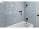 Bathroom showcasing blue subway tile in shower with inset shelf and white porcelain tub at 2300 Newport Lndg, Alpharetta, GA 30009