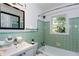 Bright bathroom featuring green tile, a tub, toilet, and a framed mirror at 247 Heaton Park Dr, Atlanta, GA 30030