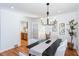 Bright dining room with modern light fixture, hardwood floors, and view into the kitchen through glass doors at 247 Heaton Park Dr, Atlanta, GA 30030