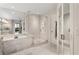 Luxurious primary bathroom with white marble accents, glass shower, and soaking tub at 2660 Peachtree Nw Rd # 11G, Atlanta, GA 30305