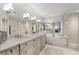 Elegant bathroom featuring a double vanity, large mirror, soaking tub, and glass-enclosed shower at 2660 Peachtree Nw Rd # 11G, Atlanta, GA 30305