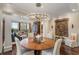 Well-lit dining room with a round wooden table, chandelier, and view of the connected living area at 2660 Peachtree Nw Rd # 11G, Atlanta, GA 30305