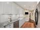 Updated kitchen featuring stainless steel appliances, granite countertops, and hardwood floors with sleek white cabinetry at 2660 Peachtree Nw Rd # 11G, Atlanta, GA 30305