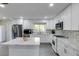 Bright kitchen featuring an island, white cabinetry, stainless steel appliances, and a gray backsplash at 285 Glen Lake Dr, Sandy Springs, GA 30327