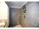 Contemporary shower with gray tile and a built-in shelving unit for toiletries at 301 Eleanora Xing, Loganville, GA 30052