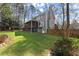 Large backyard with green grass, landscaping, covered porch, and a view of mature trees at 4165 Liberty Trce, Marietta, GA 30066