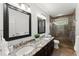 Well-lit bathroom with dual sinks, granite counters, and a glass-enclosed shower at 4165 Liberty Trce, Marietta, GA 30066