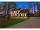 Gorgeous two-story brick home at dusk, featuring a manicured lawn and welcoming driveway at 4165 Liberty Trce, Marietta, GA 30066