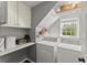 Functional laundry room with storage shelves, front load washer and dryer, and natural light at 4165 Liberty Trce, Marietta, GA 30066