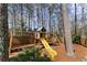 Backyard with a wooden playground, mulch and trees at 4165 Liberty Trce, Marietta, GA 30066