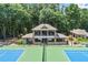 View of the community clubhouse adjacent to well-maintained tennis courts at 4165 Liberty Trce, Marietta, GA 30066