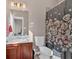 Cozy bathroom featuring floral shower curtain, modern lighting and wood vanity at 586 Shoal Mill Sw Rd, Smyrna, GA 30082