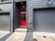 Inviting home entrance with a vibrant red door, gray siding, and convenient garage access at 166 Color Cir, Atlanta, GA 30317