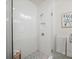 Modern shower featuring white tiled walls, a glass door, and built-in shower niche at 166 Color Cir, Atlanta, GA 30317