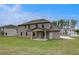 Beautiful backyard showcasing a well-manicured lawn, a covered patio, and a classic brick facade at 177 Haverling Pass, Hampton, GA 30228