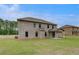 Wide backyard featuring a covered patio, and a classic brick facade surrounded by lush greenery at 177 Haverling Pass, Hampton, GA 30228