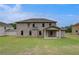 Expansive backyard featuring a well-maintained lawn, a covered patio, and a charming brick exterior at 177 Haverling Pass, Hampton, GA 30228