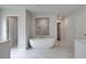 Serene bathroom features a sleek standalone tub, marble tile, and a glass-enclosed shower at 177 Haverling Pass, Hampton, GA 30228