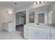 Bright bathroom showcasing double vanities with white cabinetry and elegant mirrors, complemented by stylish tile flooring at 177 Haverling Pass, Hampton, GA 30228