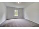 Clean, carpeted bedroom with a large window overlooking a green space at 177 Haverling Pass, Hampton, GA 30228