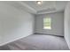 Cozy bedroom showcasing neutral walls, plush carpet, and tray ceiling with natural light at 177 Haverling Pass, Hampton, GA 30228