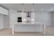 Bright, white kitchen features a large island, stainless steel appliances, and modern pendant lighting at 177 Haverling Pass, Hampton, GA 30228