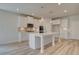 View of bright kitchen featuring white cabinets, stainless steel appliances and a large center island with pendant lighting at 177 Haverling Pass, Hampton, GA 30228