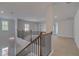 Bright loft featuring hardwood floors, elegant chandelier, and a classic wood and metal railing at 177 Haverling Pass, Hampton, GA 30228