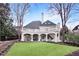 Elegant home features a lush backyard with a white exterior, covered patio, and manicured lawn at 3196 Andrews Nw Ct, Atlanta, GA 30305