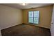 A standard bedroom with neutral walls, carpet flooring, and a window at 5928 Springfair Run, Lithonia, GA 30038