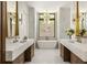 Elegant bathroom with marble countertops, dual sinks, modern lighting, and a freestanding soaking tub at 1131 Lupo Loop, Chattahoochee Hills, GA 30268