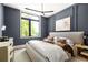 Stylish bedroom featuring large window, navy walls, modern lighting, and neutral decor at 1131 Lupo Loop, Chattahoochee Hills, GA 30268