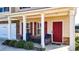 Inviting front porch with comfortable seating, columns, and a red front door at 117 Cottage Nw Walk, Cartersville, GA 30121
