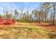 Large backyard view from red deck with grass and trees at 12348 Hillcrest Dr, Hampton, GA 30228