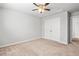 This bedroom boasts a ceiling fan, closet with double doors, and neutral carpet at 12348 Hillcrest Dr, Hampton, GA 30228