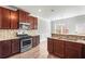 Well-lit kitchen features wooden cabinets, stainless steel appliances, and granite countertops at 12348 Hillcrest Dr, Hampton, GA 30228