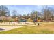 Exterior view of fenced-in playground area with colorful playsets and mature trees providing shade at 12348 Hillcrest Dr, Hampton, GA 30228