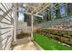 The backyard featuring stone retaining wall, pergola, and artificial turf at 2474 Norwood Park Xing, Atlanta, GA 30340