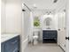 Modern bathroom featuring a shower/tub combo, navy blue vanity and a round mirror at 5980 Mallet Ct, Cumming, GA 30040